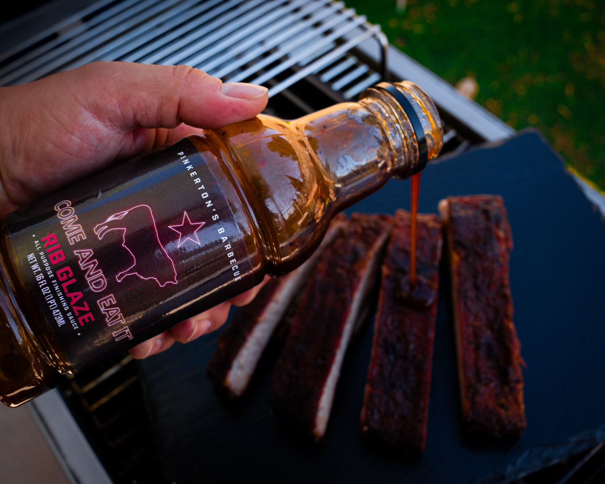 pouring pinkertons rib glaze on pork ribs