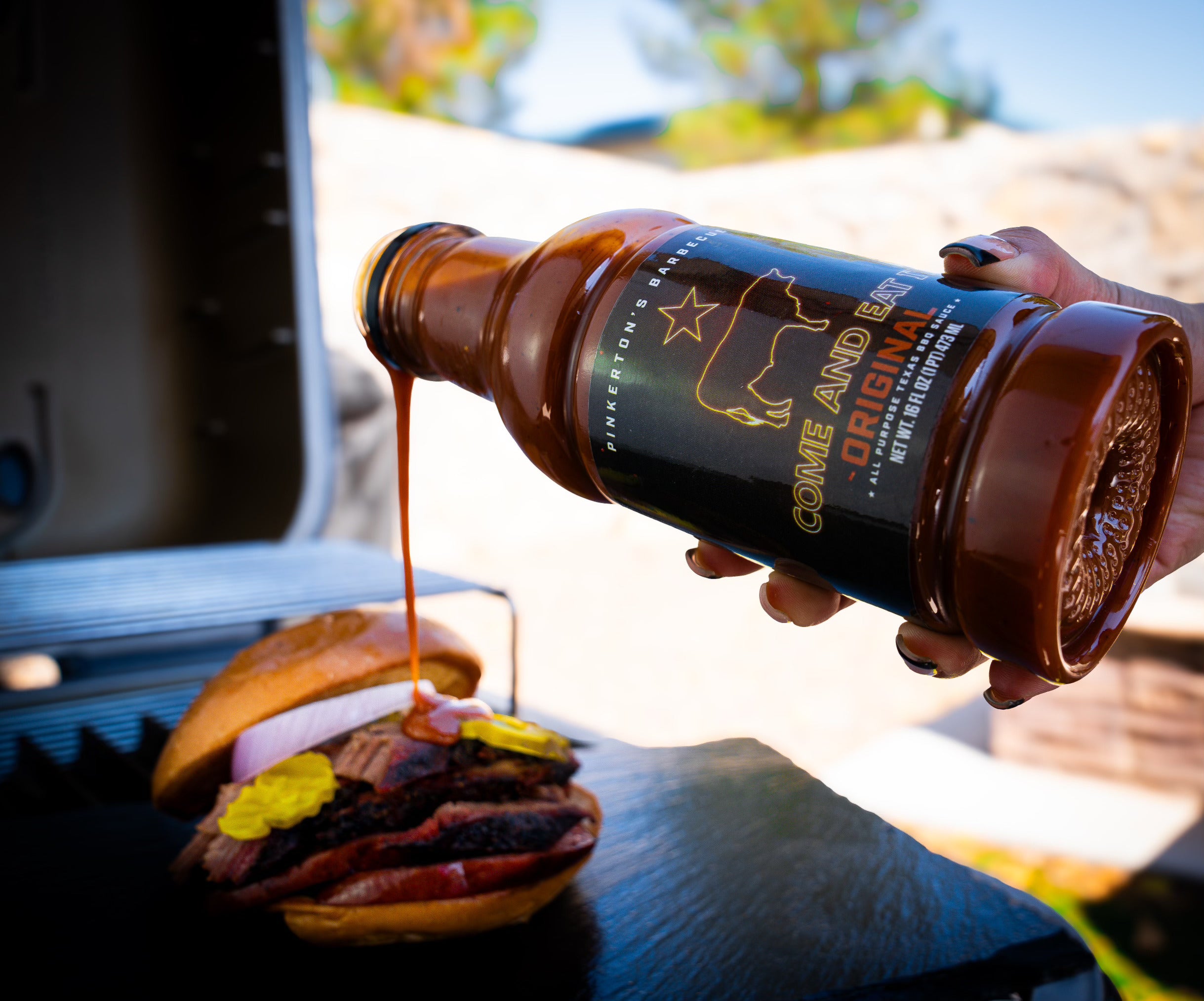 Pinkerton’s Original BBQ Sauce poured over a brisket sandwich